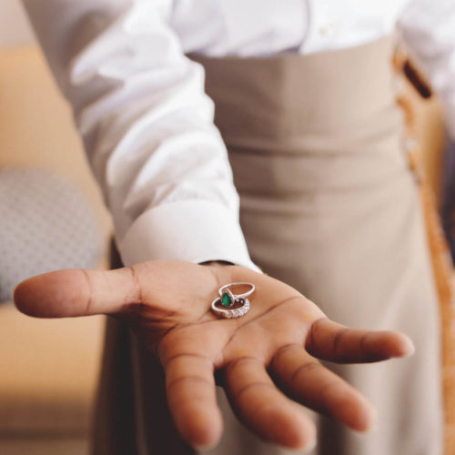 Close up of rings in grooms hands.