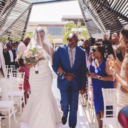 Bride walking down the aisle with father at Royalton Riviera Cancun Resort
