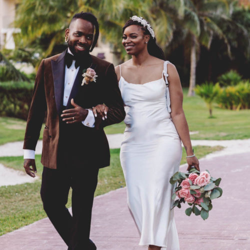 Morgan and Josh laughing as they walk down path at Royalton Riviera Cancun Resort shortly after their wedding.