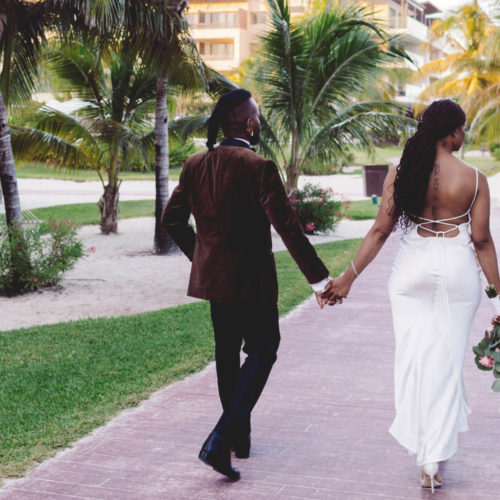 Bride and groom from behind walking away in garden's at Royalton Riviera Cancun Resort