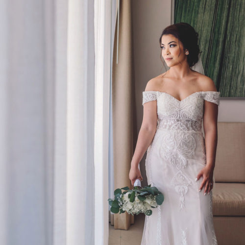 Authentic portrait of bride looking out window at Royalton Riviera Cancun